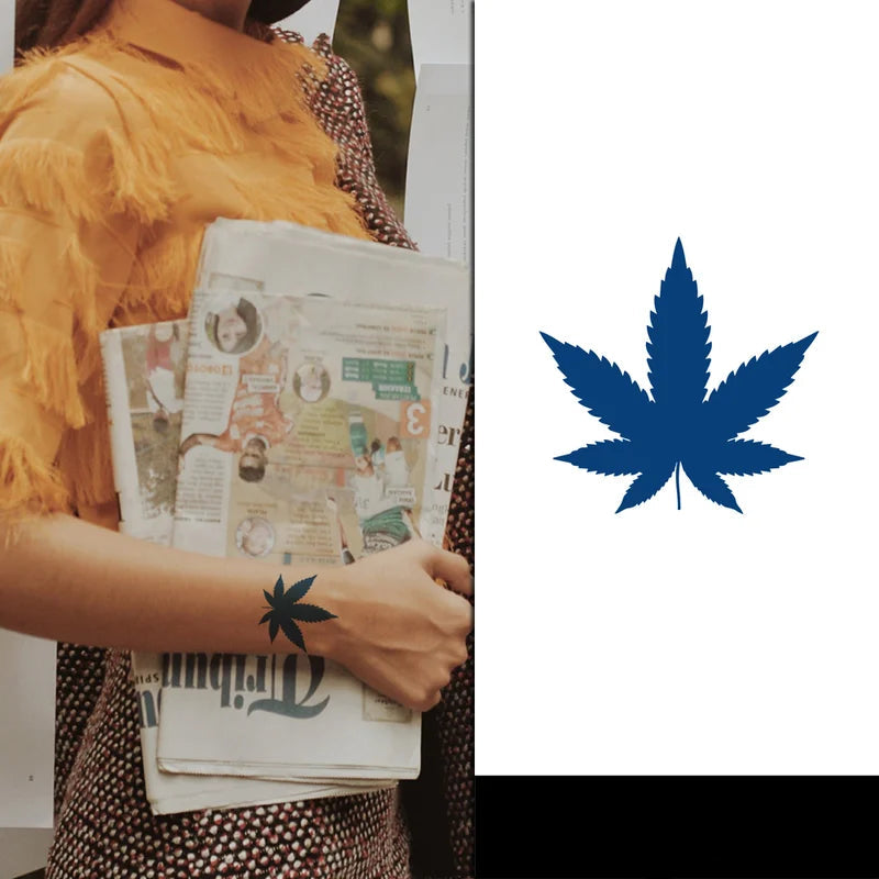 Person holding a newspaper with a blue cannabis leaf symbol tattoo