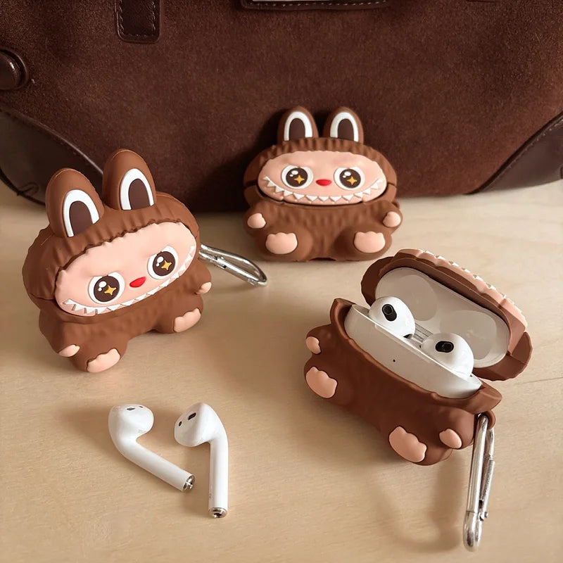 Three cartoonish brown animal-themed airpod cases with white airpods on a beige surface.