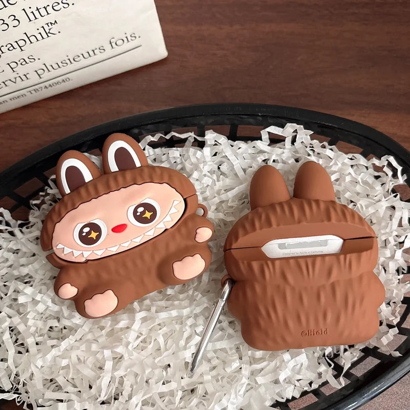 Two brown animal-themed airpod cases on a bed of white shredded paper.
