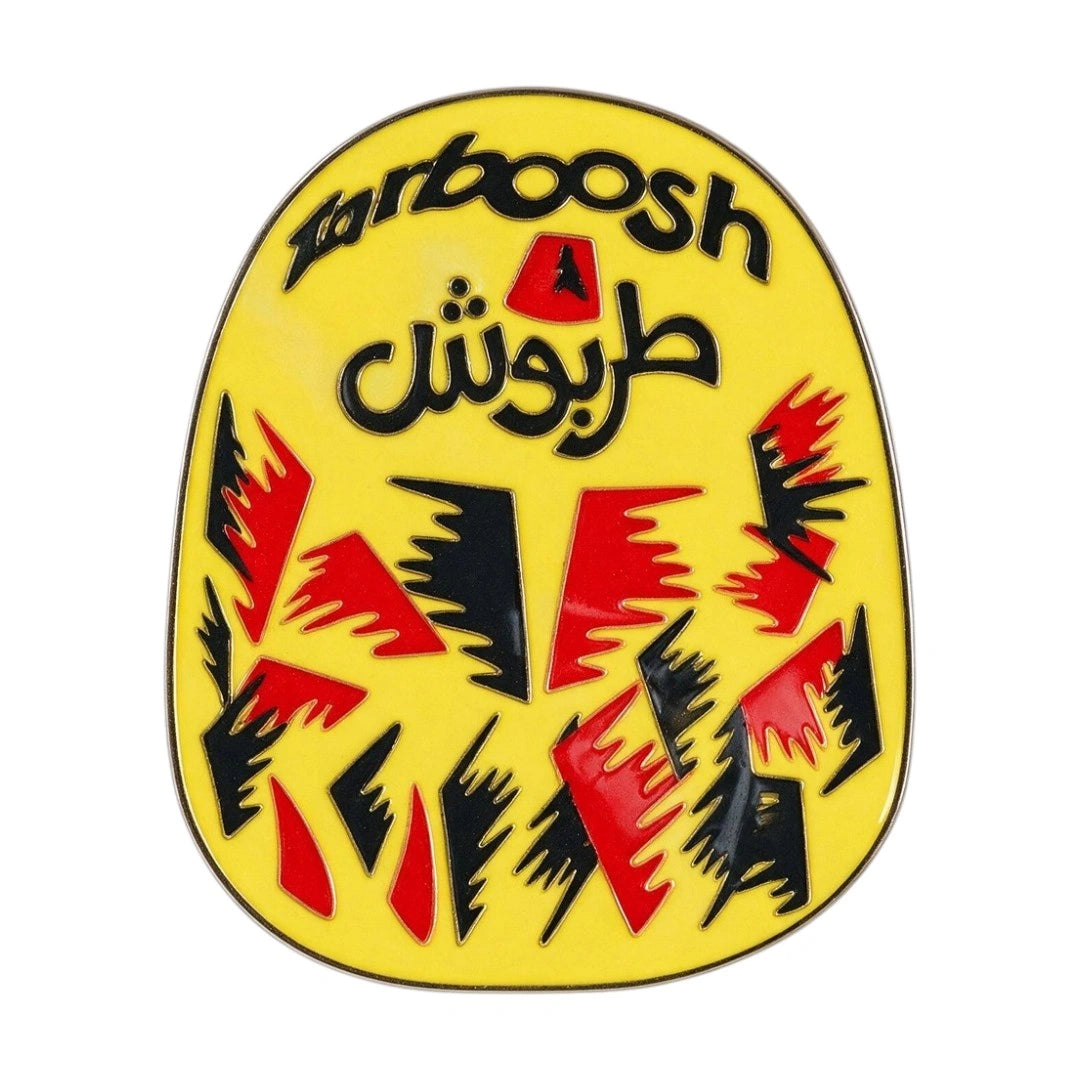 A yellow enamel pin featuring the word 'barboosh' in black script and Arabic text 'العربية' in black, with red and black abstract graphic shapes on a white background.