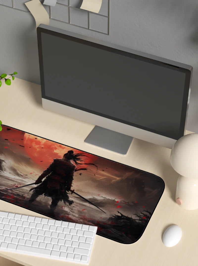 Computer setup with a large mouse pad featuring a warrior design on a desk.