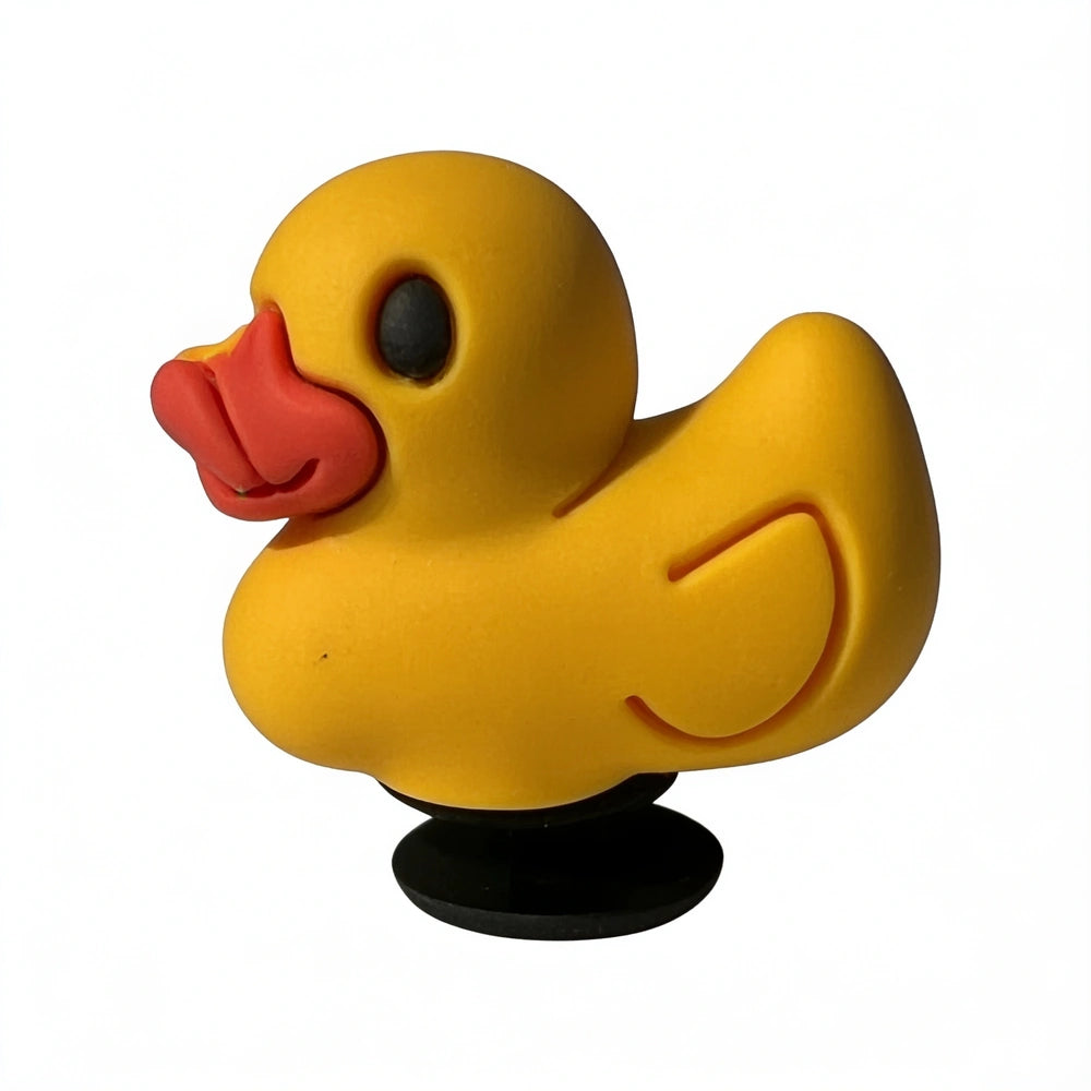 Yellow rubber duck with a black suction cup on a white background