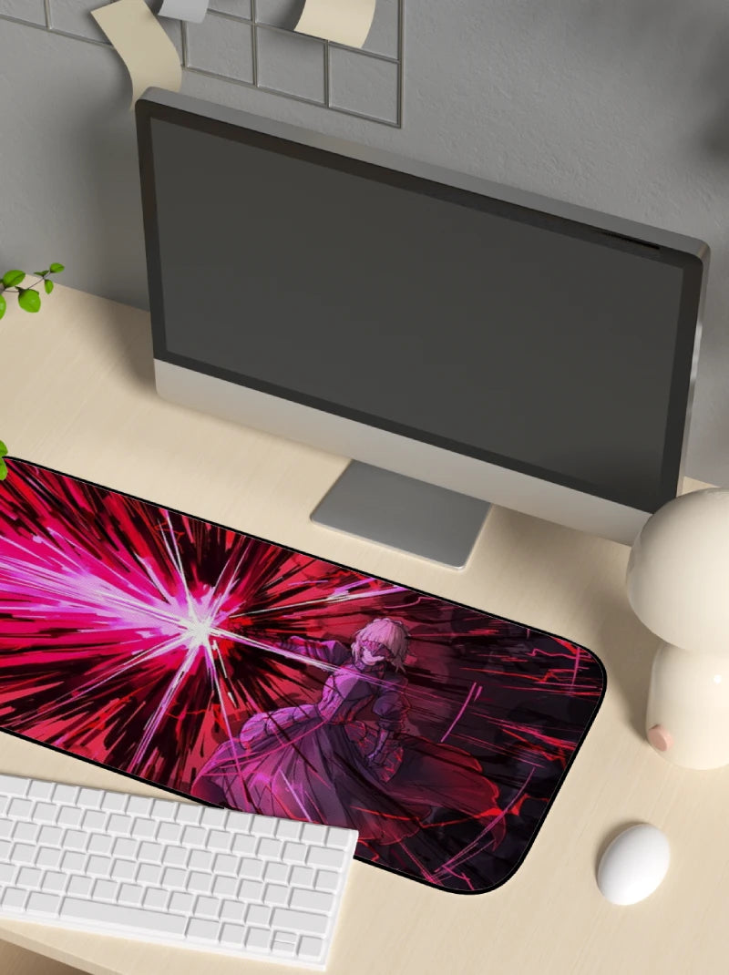 Desk setup with a computer monitor, keyboard, and mouse on a desk with a colorful mouse pad.