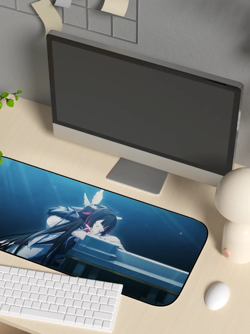 Desk setup with a computer monitor, keyboard, and mouse on a desk with an anime-themed mouse pad.