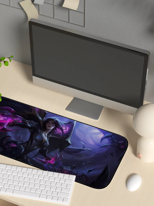Computer monitor on a desk with a large mouse pad featuring a fantasy design.