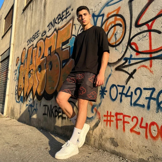 model leaning against wall wearing a black tshirt and black mesh shorts