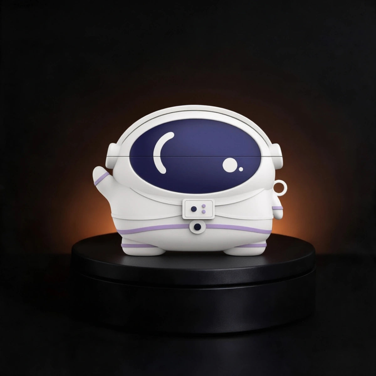 A white astronaut-shaped case for airpods and buds,  with a dark blue visor and subtle purple accents, displayed on a black circular pedestal against a dark background with warm light glow.