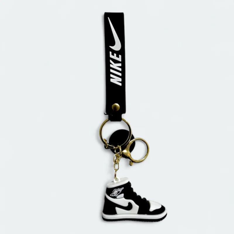 Nike keychain with a black strap and a shoe-shaped charm on a white background