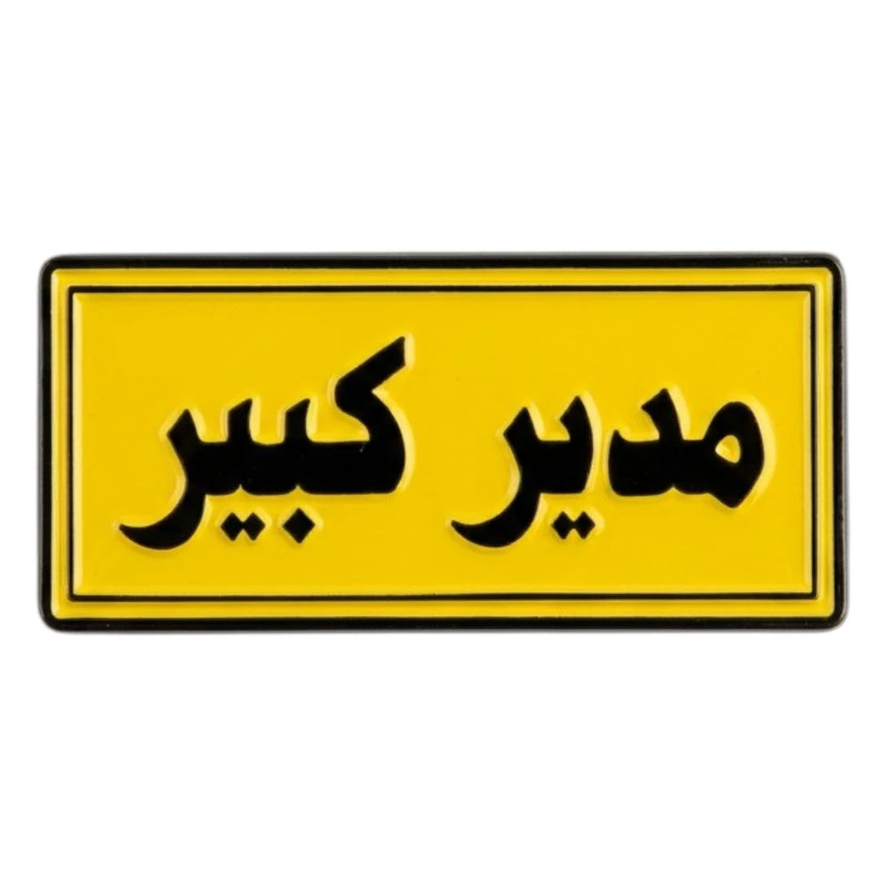 Yellow rectangular sign with black Arabic text on a white background
