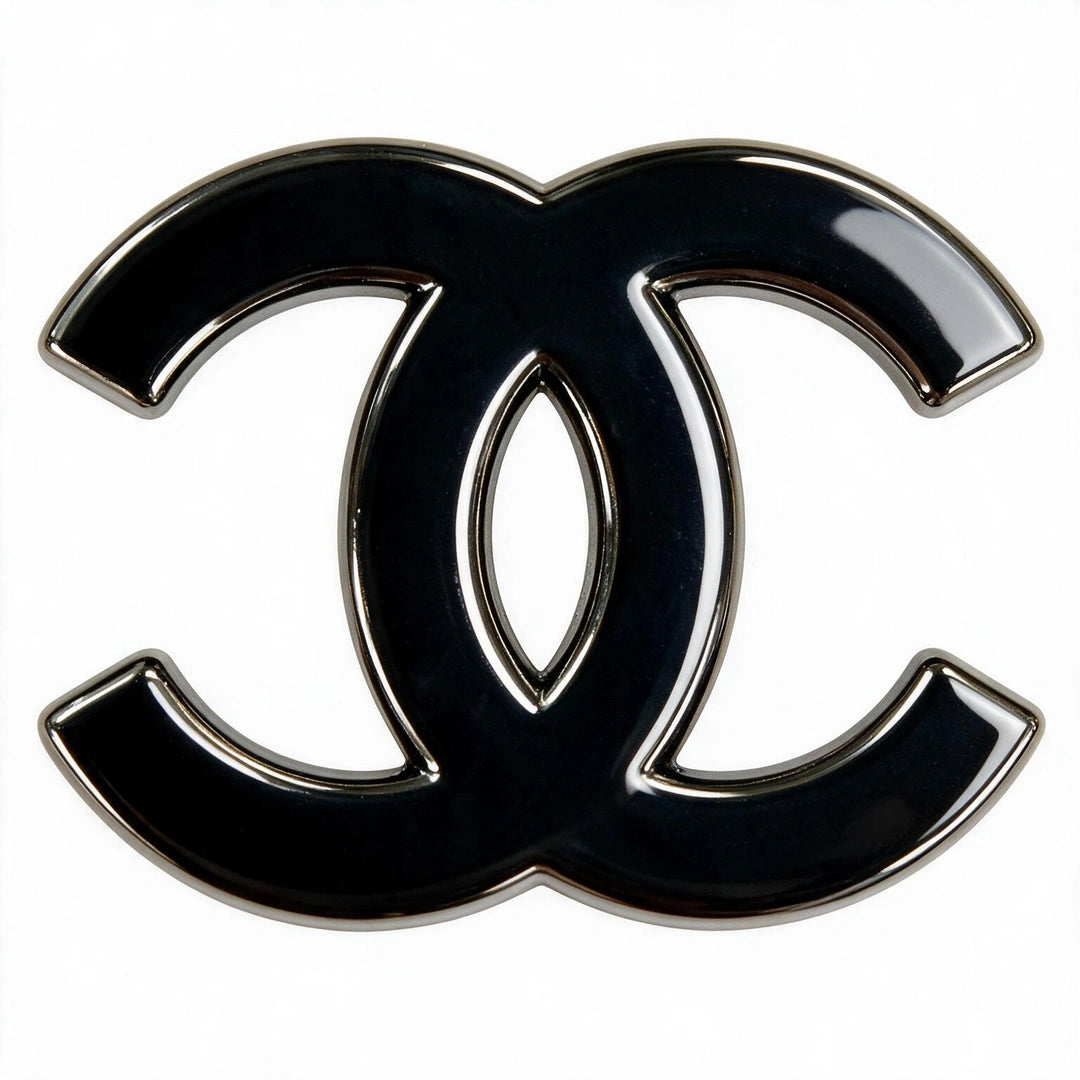 A glossy black interlocking CC logo charm with a polished silver-tone metal border, set against a plain white background.