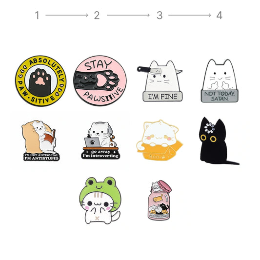 A set of cute cartoon cat enamel pins arranged on a plain white background, with a small numbered guide at the top suggesting how to assemble or view the pins. The pins feature various designs including a yellow paw print pin, a pink paw print pin, a white cat pin with a bowtie, a gray cat pin with a sign, a white cat pin reading 'I'M FINE', a black cat pin, a frog pin, and a jar pin.