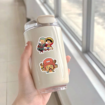 Hand holding a tumbler with anime character stickers against a neutral background