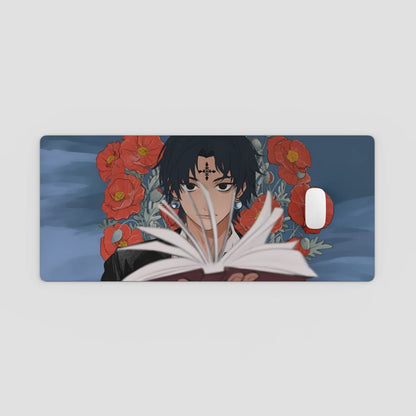 Desk Mat with anime character reading a book and red flowers on a blue background
