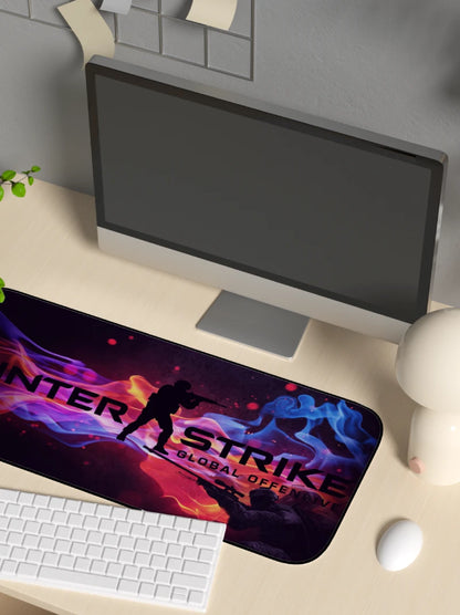 Desk setup with a computer monitor, keyboard, and mouse pad featuring 'Counter-Strike: Global Offensive' design.