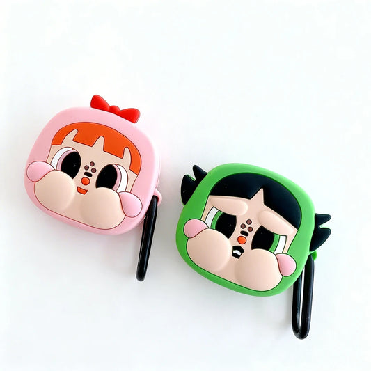 Two cartoon character-themed airpod cases, one pink and one green, on a white background.