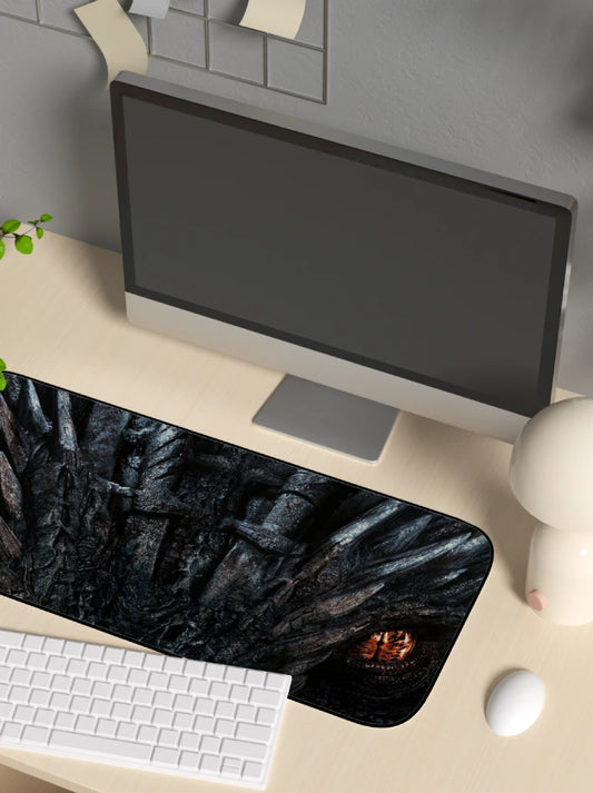 Computer setup with a monitor, keyboard, and game of thrones drogon  mouse pad on a desk.