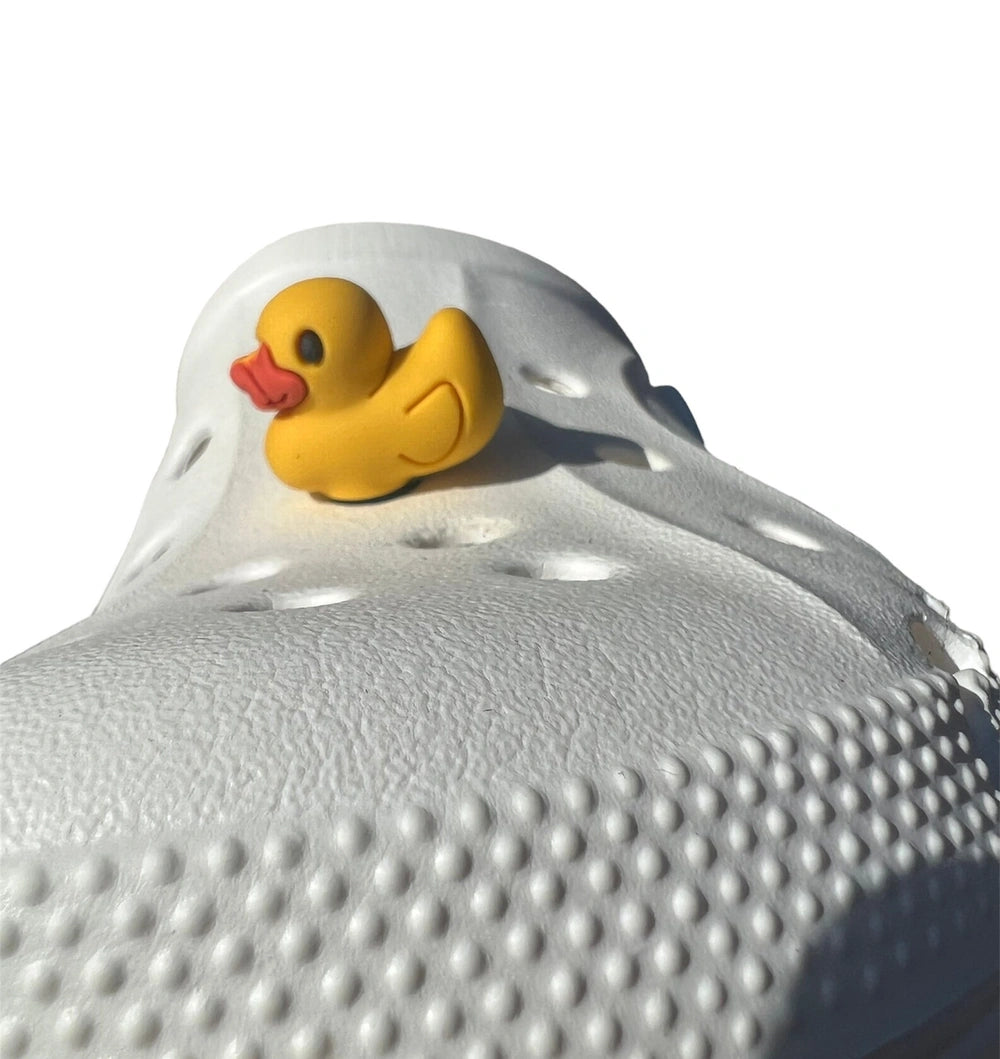 Yellow rubber duck on top of a white textured object