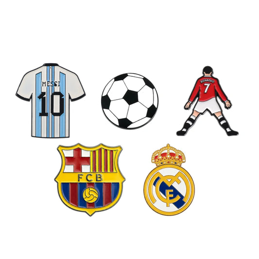 A set of five soccer-themed enamel pins or stickers on a plain white background: a striped Argentina jersey with 'MESSI 10', a black-and-white soccer ball, a football player in a red jersey, the FC Barcelona crest, and the Real Madrid crest.
