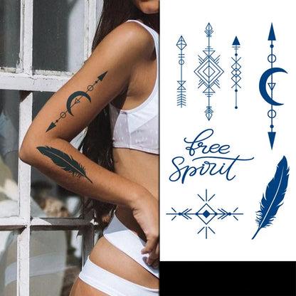 Woman with temporary tattoos on her arm, featuring geometric designs and the text 'Free Spirit'.