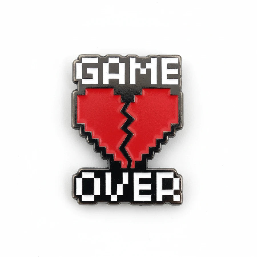 Pixelated 'GAME OVER' heart-shaped enamel pin on a white background