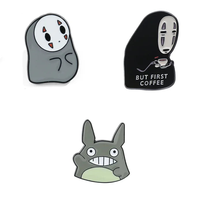 Three cartoon character pins on a white background