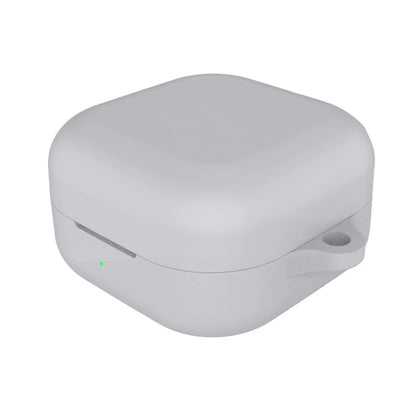 White wireless earbuds case with a green indicator light on a white background