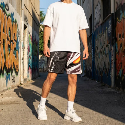 Person wearing a white t-shirt and patterned shorts standing in an alley with graffiti on the walls.