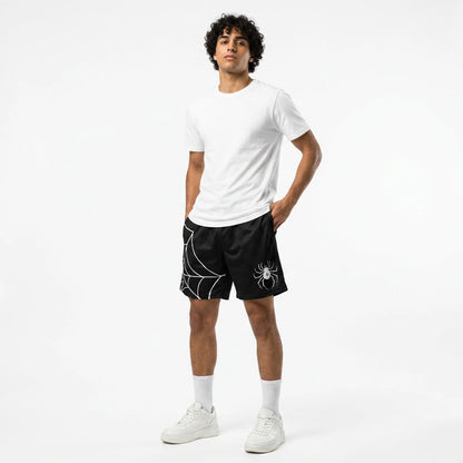 Man wearing a white t-shirt and black shorts with a spider design on a white background