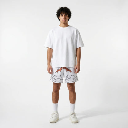 Person wearing a white t-shirt and shorts with a pattern on a plain background