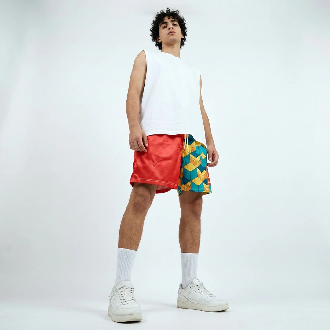 Person wearing a white sleeveless shirt, red and multicolored shorts on a white background