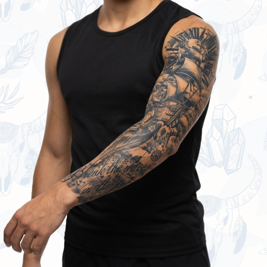 Man wearing a black sleeveless shirt with tattoos on his arm against a light background