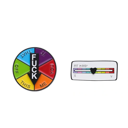 Two novelty enamel pins on a plain white background: a circular pin divided into rainbow segments with the word 'FUCK' in the center, and a rectangular pin showing a mood slider with rainbow colors and a black heart.