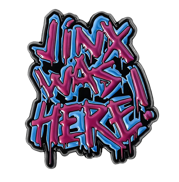 Graffiti-style badge with 'Jinx Was Here!' text in pink and blue on a white background