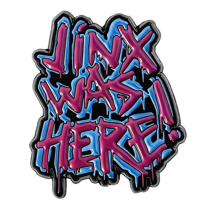 Graffiti-style badge with 'Jinx Was Here!' text in pink and blue on a white background