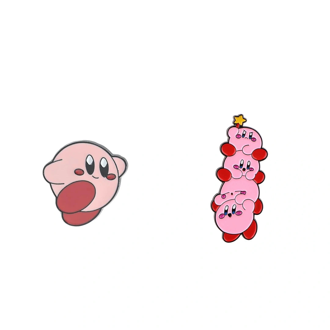 Two Kirby-themed enamel pins on a plain white background: one pin shows Kirby's face with its tongue sticking out, and the other shows a stacked, four-headed Kirby with a small yellow star on top.