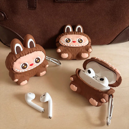 Three cartoonish brown animal-themed airpod cases with white airpods on a beige surface.