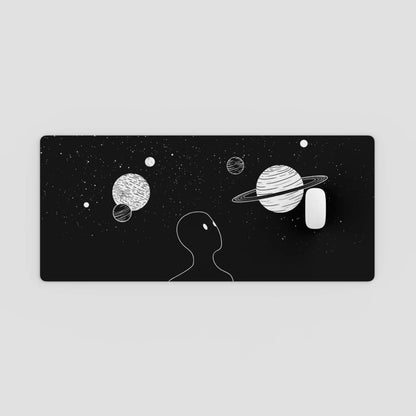 Black rectangular plate with white illustrations of planets and a silhouette of a person against a starry background.