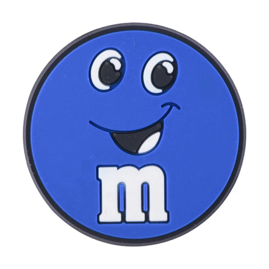 Blue M&M croc charm with a smile on a white background