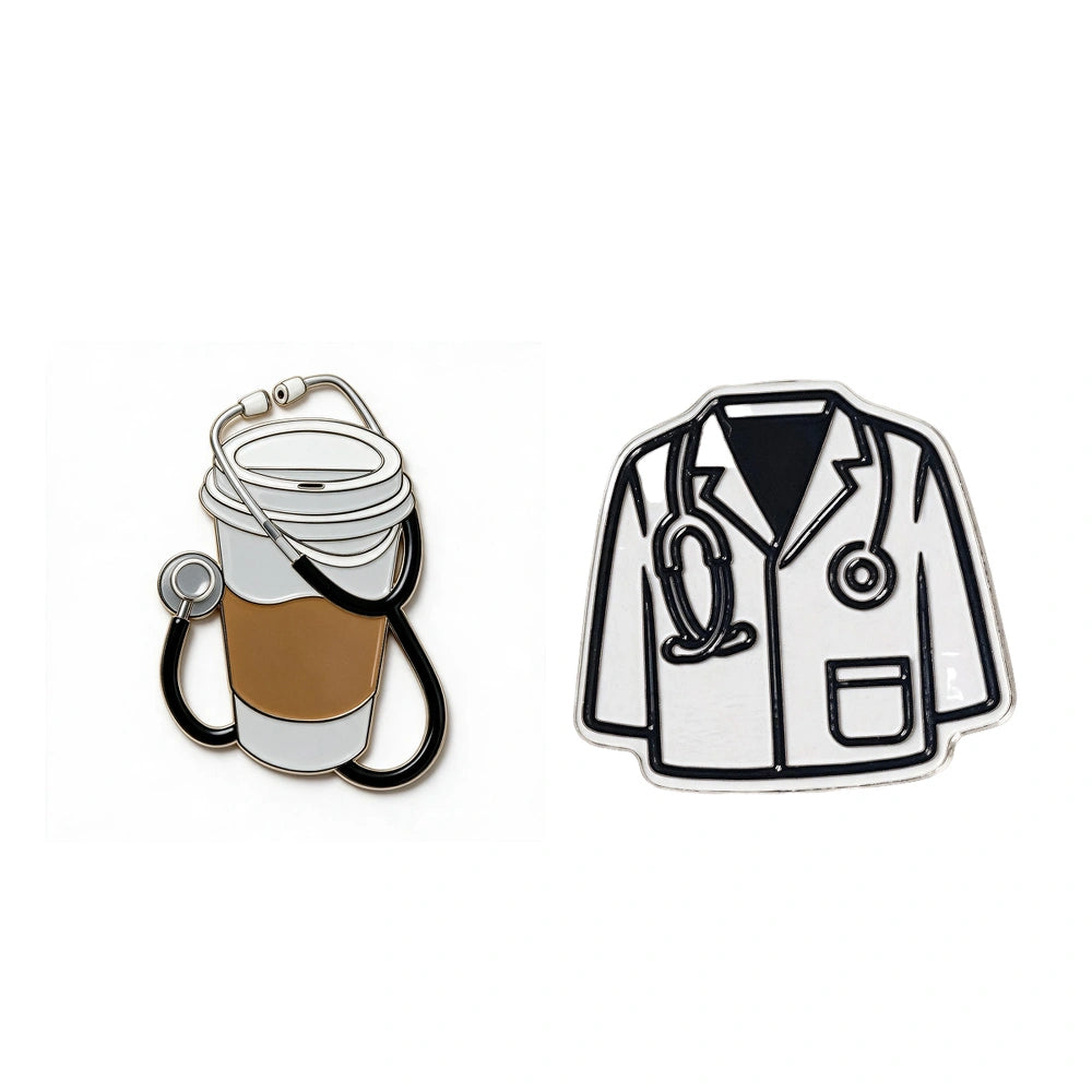 Two enamel pins on a plain white background: one shaped like a takeaway coffee cup with a stethoscope draped around it, and one shaped like a doctor's lab coat with a stethoscope at the neck.