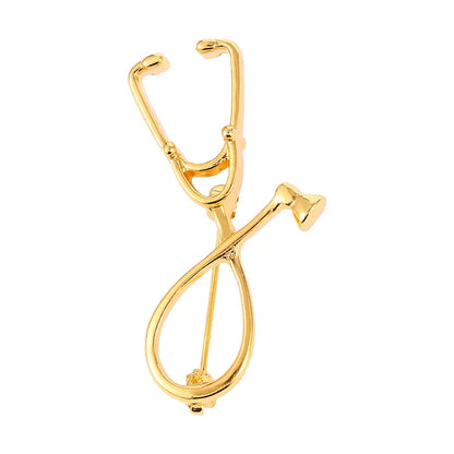 Gold stethoscope-shaped brooch on a white background