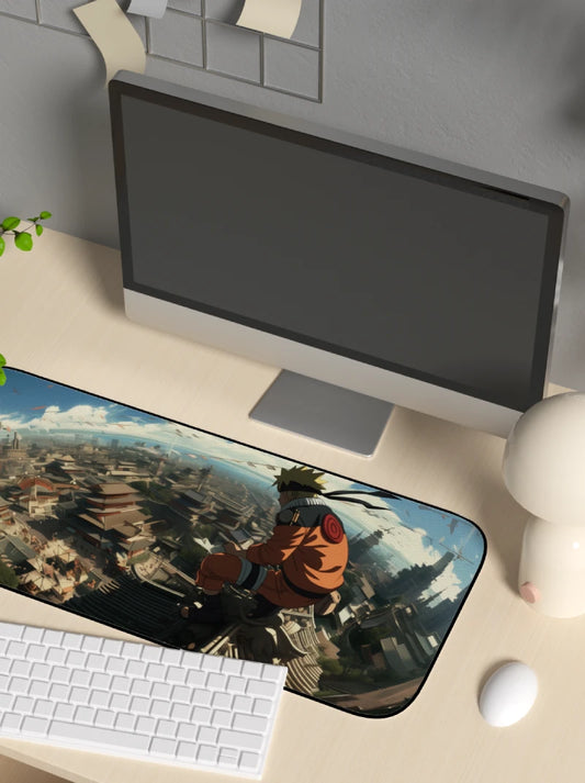 Desk setup with a computer monitor, keyboard, and mouse pad featuring a cityscape design of konohagakure from Naruto Shippuden.