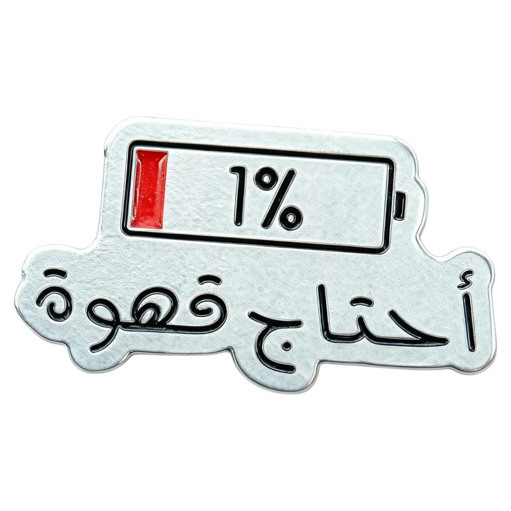 Metallic badge with battery indicator showing 1% and Arabic text on a white background
