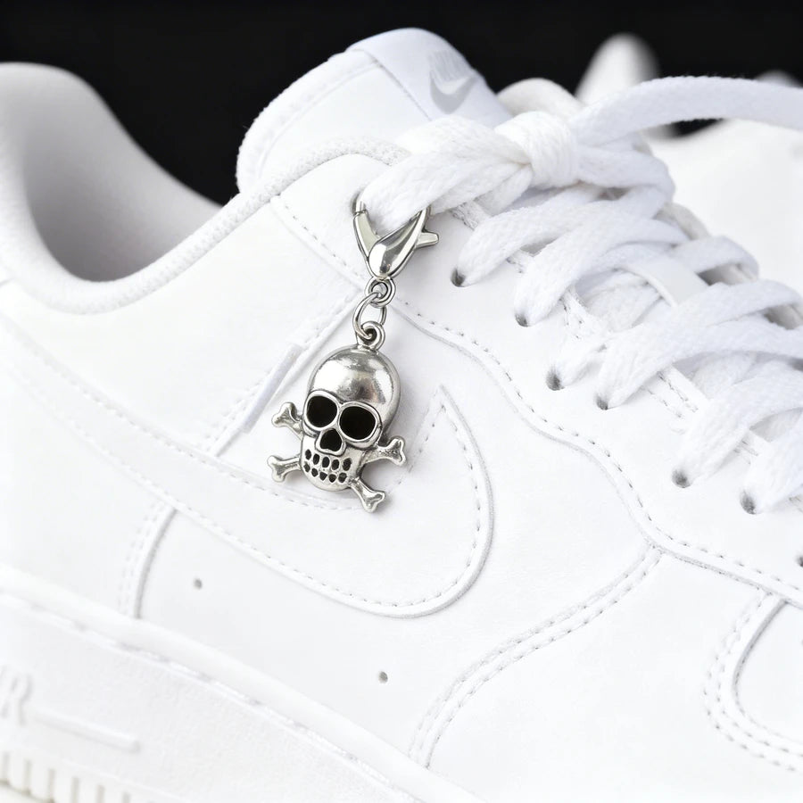 White sneaker with a skull charm on the lace