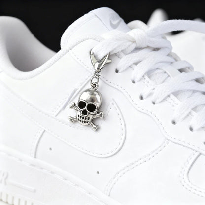 White sneaker with a skull charm on the lace