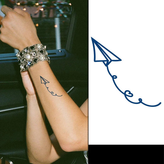 Person with a decorative bracelet and tattoo of a paper airplane,