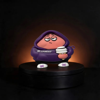 A stylized collectible figure of a pink character Patrick from spongebob case for airpods and buds wearing a purple hoodie with 'UPBEAT' printed on the chest, standing on a black circular platform against a dark background with warm light glow.