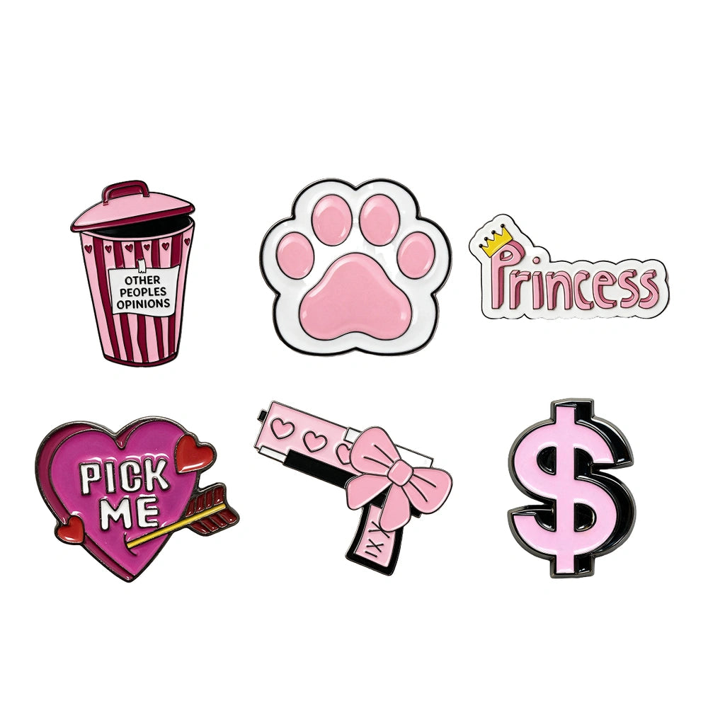 Six cartoon enamel phone sticker designs on a plain white background: a pink-and-white striped popcorn bucket with text, a pink paw print, a pink 'Princess' badge with a small gold crown, a pink heart with 'PICK ME' and an arrow, a pink-and-white pistol with a bow, and a pink dollar sign.
