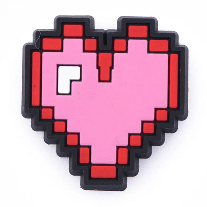 Pixelated heart-shaped croc charm with a pink center and red outlines on a white background
