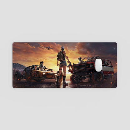 desk mat with a desert scene featuring vehicles and people against a sunset sky.