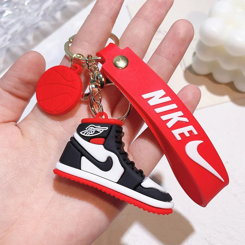 Keychain with Nike logo and shoe design held in a hand